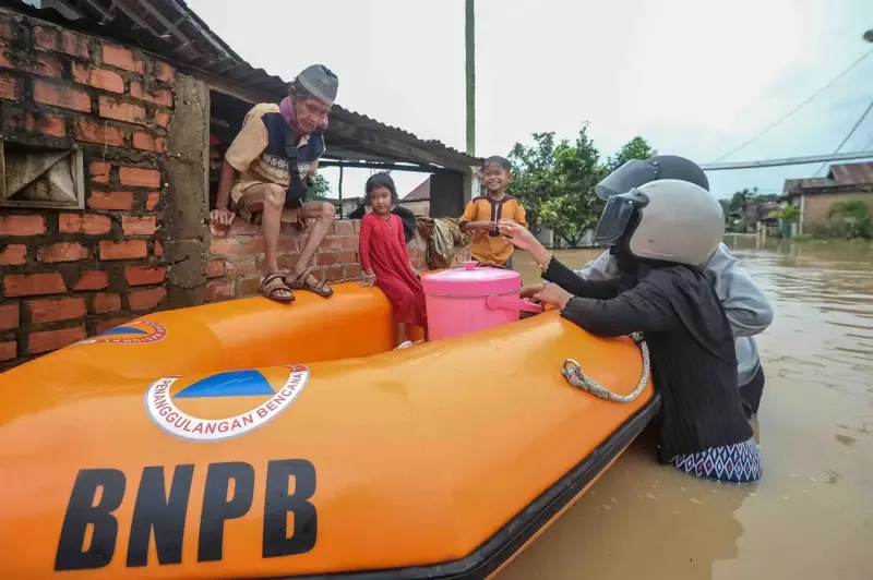 Warga mengevakuasi korban banjir menggunakan perahu karet BNPB di Kenali Besar, Jambi, Minggu (30/03).