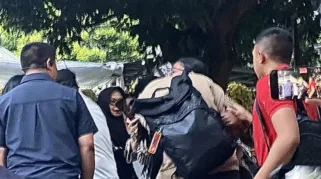 Momen anak bungsu Marsma Fajar Adriyanto, Akmal Fadhillah Kusuma memeluk erat ibunya dalam tangis di depan rumah duka Marsma TNI Fajar Adriyanto, Minggu (3/8/2025).